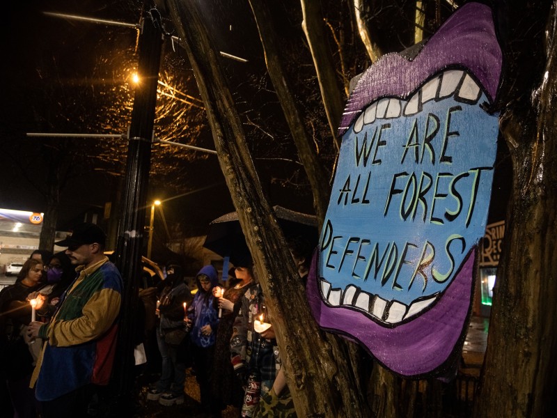 Activists holding a vigil on Jan. 19 for the forest defender Tortuguita, who was killed by a Georgia State Patrol Swat team during a multijurisdictional raid of the Weelaunee Forest on Jan. 18