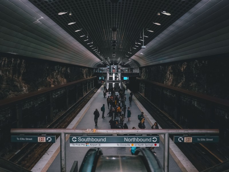 A darkened image of Peachtree Center MARTA station with no trains in the station and a small crowd waiting on the platform
