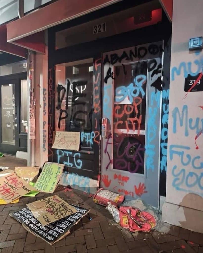L3SP's offices in Savannah, GA.  The doors and walls of the building have been covered in spraypaint and cardboard signs that all bear messages in support of the Stop Cop City and Defend the Atlanta Forest movements. Some of the graffiti reads "Stop cop city" "Fuck you" and "Die Pigs". 