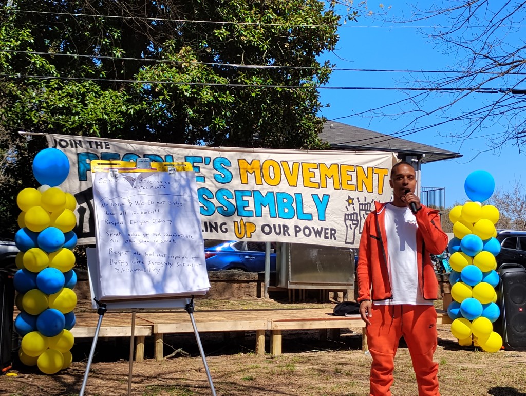 Chris Bufford stands on the People's Movement Assembly stage to explain the process through which Atlanta residents redefine public safety. 