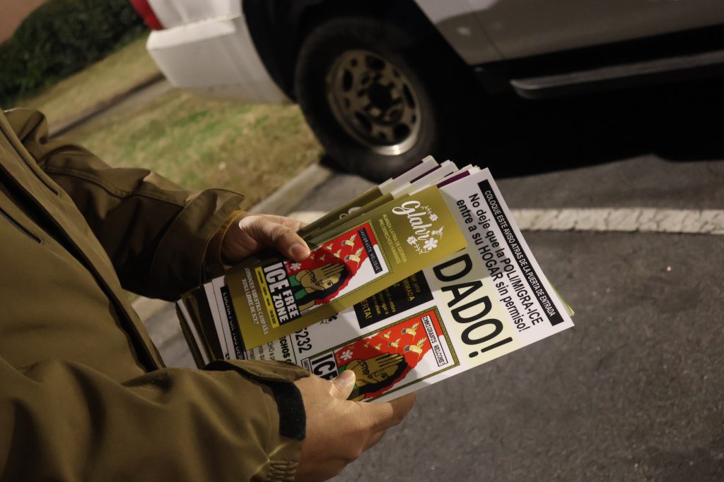 A volunteer with the Georgia Alliance for Human Rights holds a stack of Know Your Rights materials, frequently given out by ICE chasers.