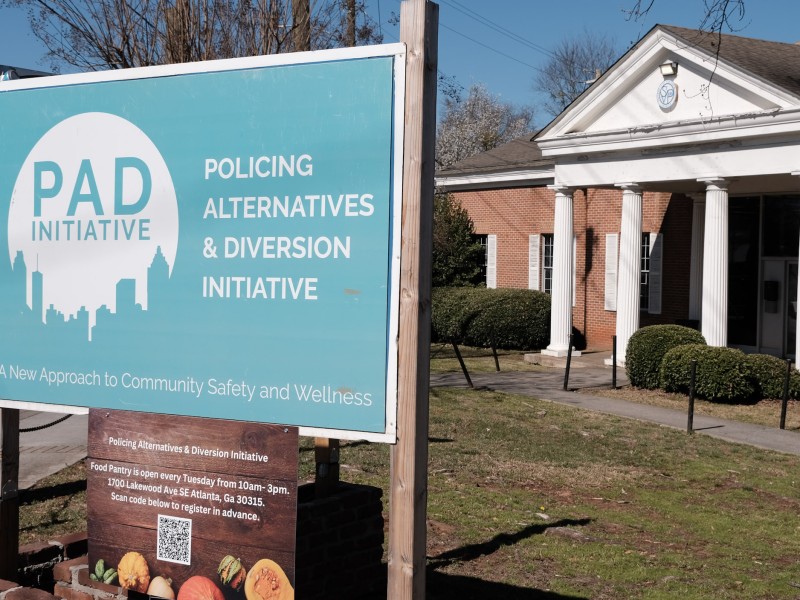 A rectangular sign for Atlanta's Policing Alternatives and Diversion Initiative (PAD Atlanta) stands outside the building the organization uses for Care Navigation.