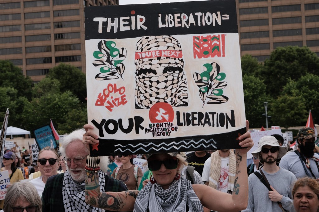 A protester holds a pro-Palestinian liberation sign during the "Stop the Billionaire Agenda" May Day rally in Downtown Atlanta. 