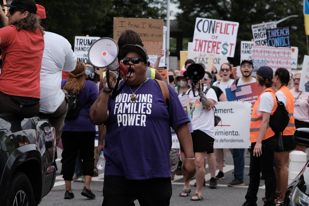 Sy Moore, an organizer with the Working Families Party, shouts into a megaphone during a workers' march on International Workers Day in Downtown Atlanta. 